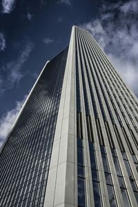 Low angle view of skyscrapers against cloudy sky