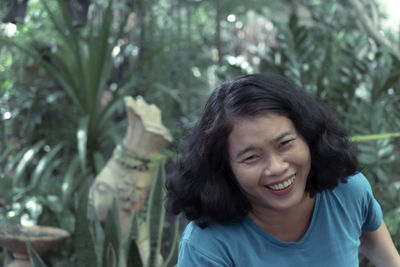 Portrait of smiling young man against plants