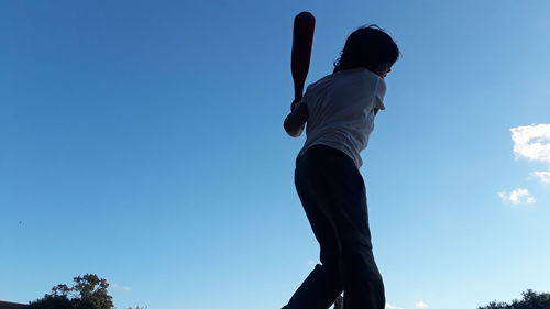 Low angle view of man against blue sky