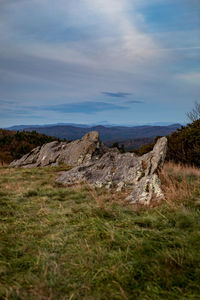 Scenic view of rocks on field against sky