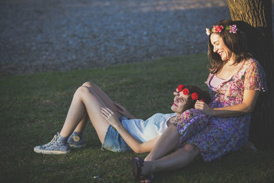 Rear view of women sitting on grass