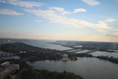 High angle view of city by sea against sky