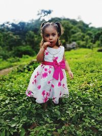 Portrait of cute girl with pink petals on field