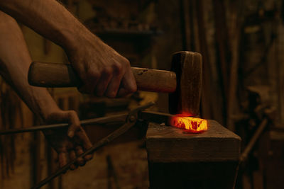 Midsection of man holding fire on wood