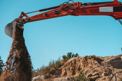 Low angle view of construction site against clear blue sky