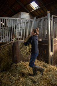 Side view of man standing in barn