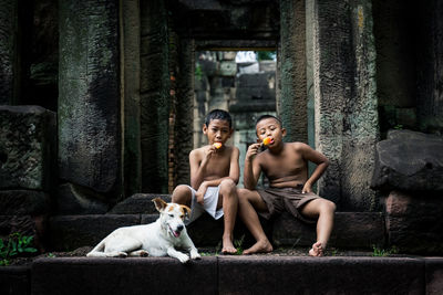 Portrait of shirtless man sitting outdoors