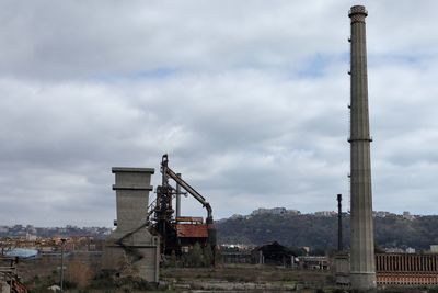 Abandoned factory against sky in city