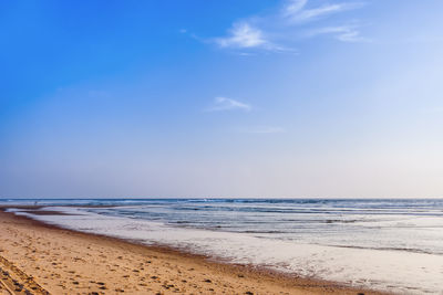 Scenic view of beach against blue sky