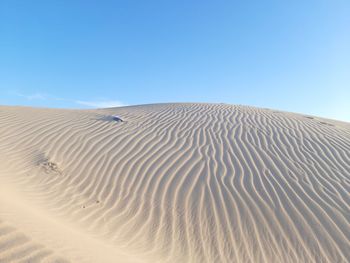 Sand dunes against clear sky