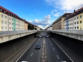Cars on road in city against sky