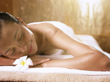 Close-up of smiling woman lying on table at spa