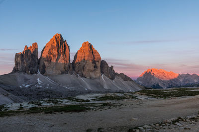 Rock formations on landscape against sky during sunset