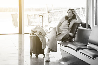 Young woman using laptop while sitting on sofa at home