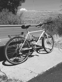 Bicycle parked on road against sky