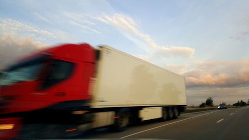 Blurred motion of car on road against sky