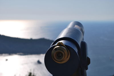 Close-up of coin-operated binoculars against sea