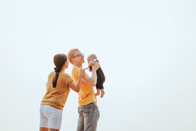 Rear view of couple standing against sky