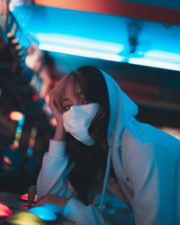 Portrait of woman looking at illuminated nightclub