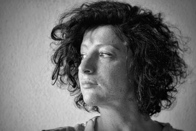 Close-up of woman with short hair against wall