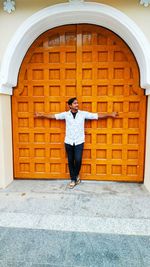 Full length of woman standing against door