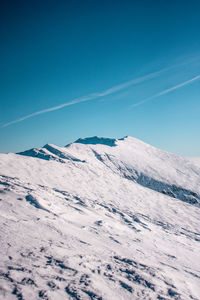 Scenic view of snowcapped mountains against clear blue sky