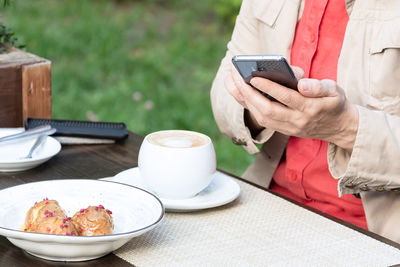 Midsection of man using laptop on table