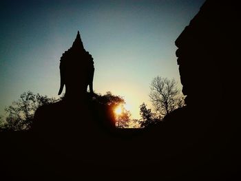 Silhouette of statue at sunset