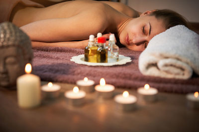 Shirtless woman lying down on floor at spa