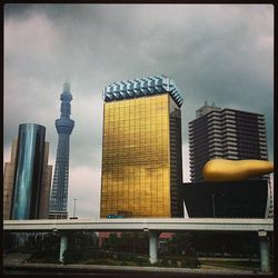 Low angle view of modern building against cloudy sky