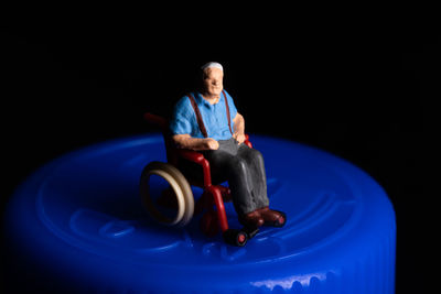 Elderly senior citizen sitting in a wheelchair that is on a medicine bottle insurance concept