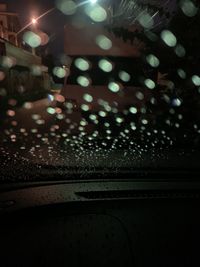 Illuminated street seen through wet window