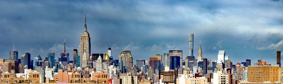 View of cityscape against cloudy sky
