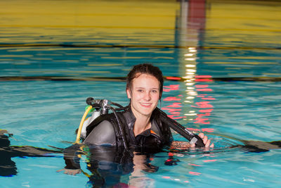 Portrait of smiling young woman swimming in pool