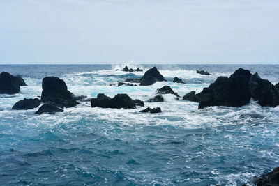 Rocks on sea shore against sky