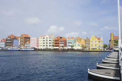 Sea by buildings against sky in city