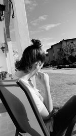 Portrait of woman sitting against sky