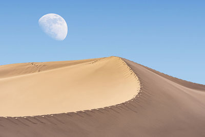 Low angle view of sand dune against clear sky