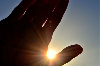 Person hand against bright sun