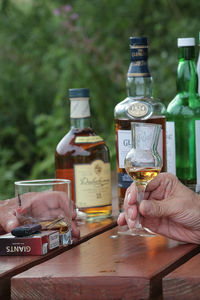 Hand holding glass bottle on table