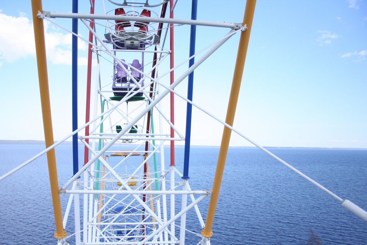 sea, built structure, water, railing, sky, architecture, blue, metal, day, sunlight, horizon over water, outdoors, no people, low angle view, transportation, nature, metallic, pier, shadow, waterfront