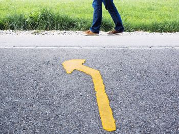 Low section of man walking by road