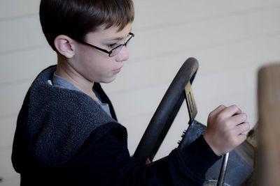 High angle view of boy using machinery at workshop