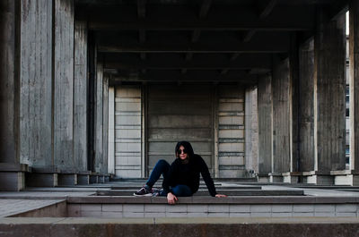 Full length of woman sitting on bridge