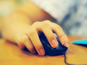 Cropped image of injured hand using computer mouse