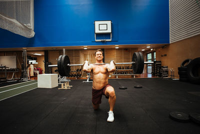 Shirtless man exercising in gym