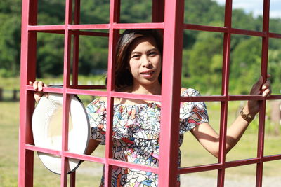 Portrait of young woman standing in metallic structure 