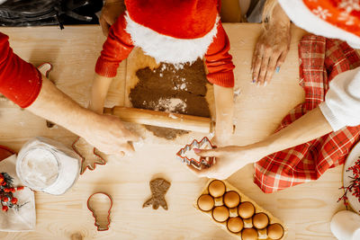 Top view of small hands roll dough holding a rolling pin. christmas cookies and holidays.