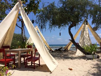 Chairs on beach against sky