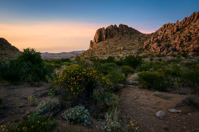 Rock formations on landscape against sky during sunset